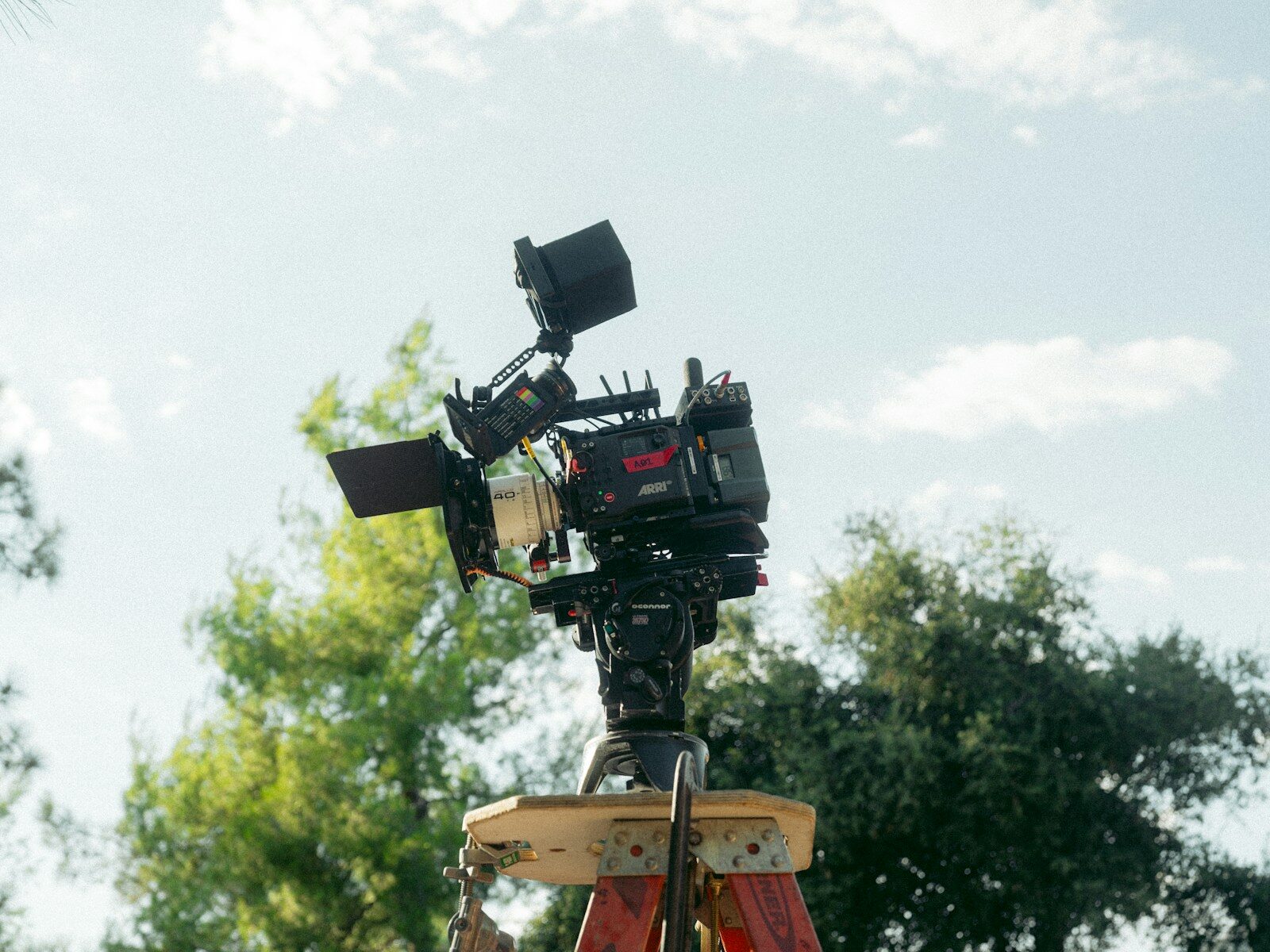 A camera set up on a wooden tripod